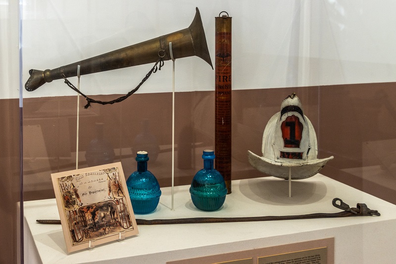 Exhibit case at Friendship Firehouse with horn and hat