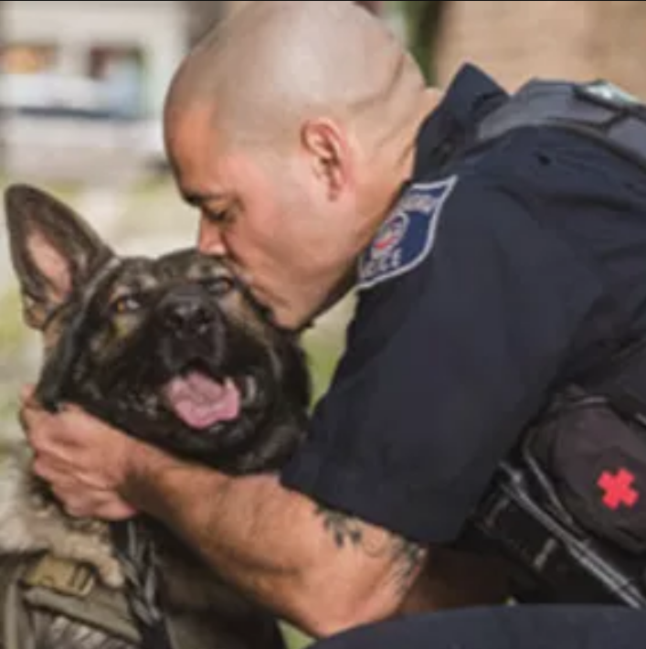 Wilson kissing a German Shepherd on the head