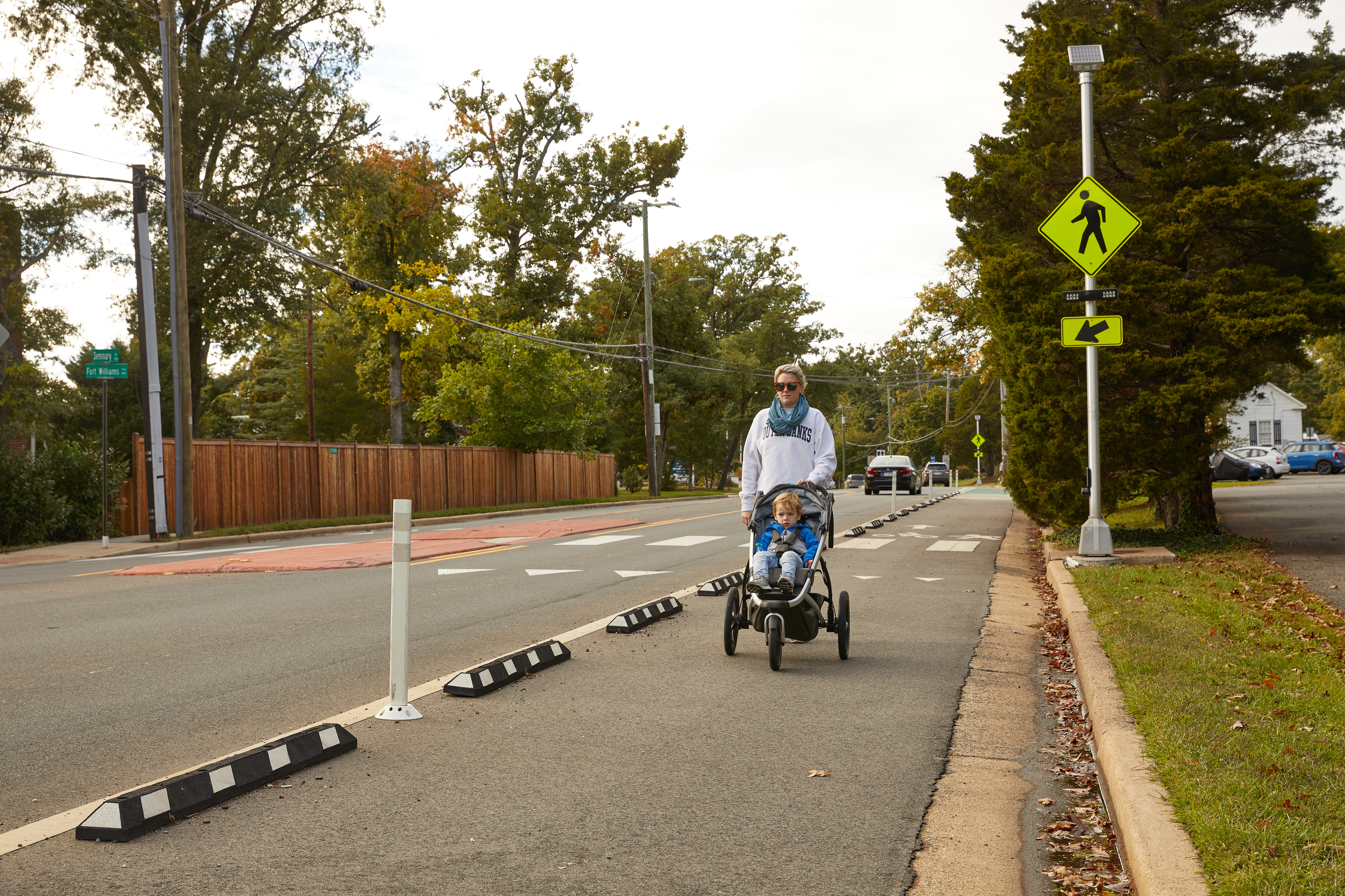 A woman pushing a stroller down Seminary Road