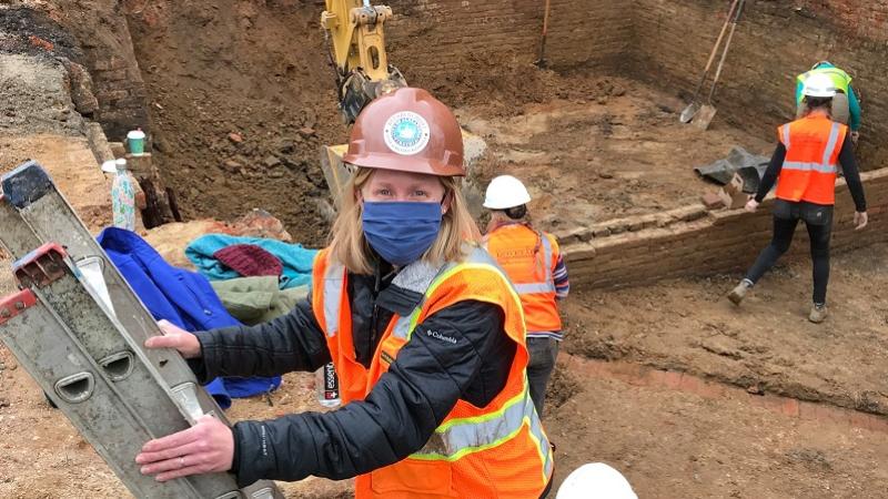 Archaeologist Eleanor Breen climbs down a ladder on site