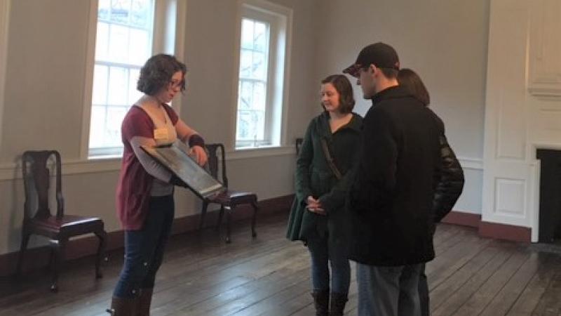 Tour guide showing image to group of guests. 