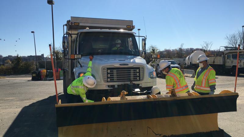 Photo of TES employees preparing a snow plow for service.