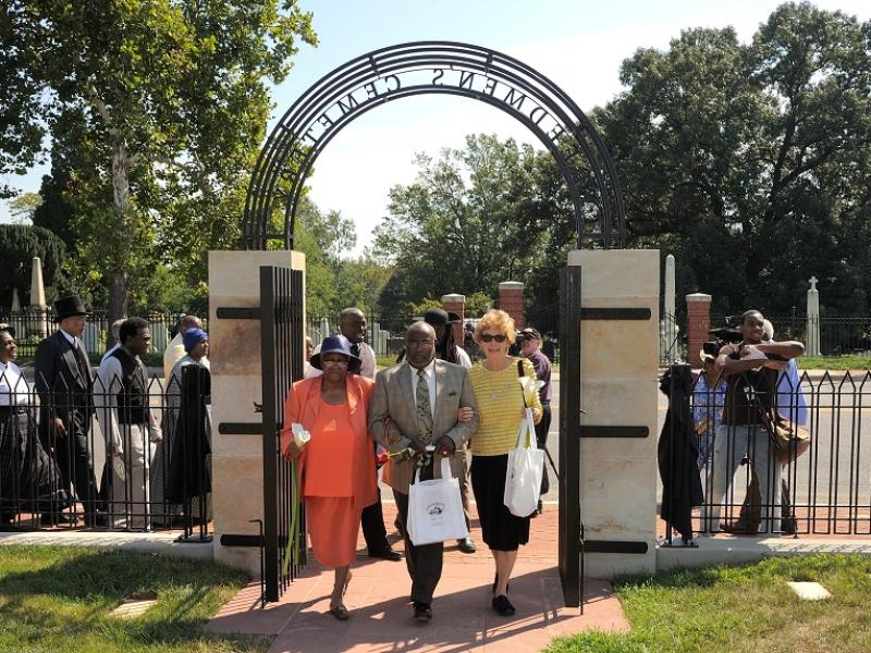 Participants at the 5th anniversary walk through the gates into the cemetery