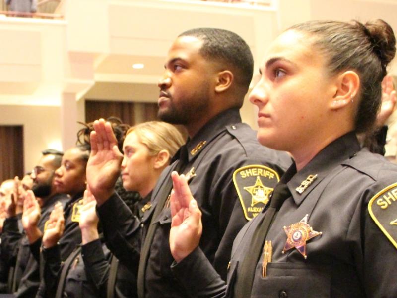 deputies in uniform holding their right hands up to take an oath