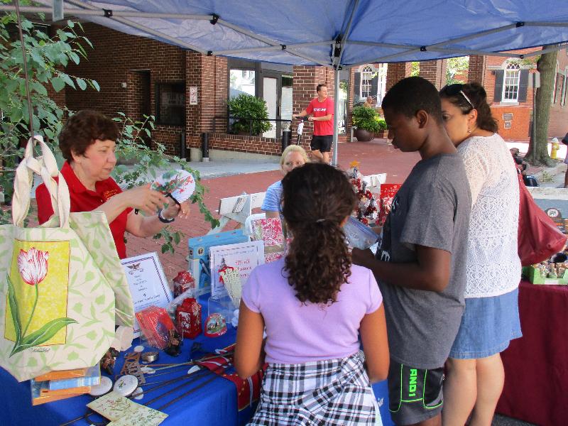 A family looks at items for sale at the Office of Historic Alexandria shop table.