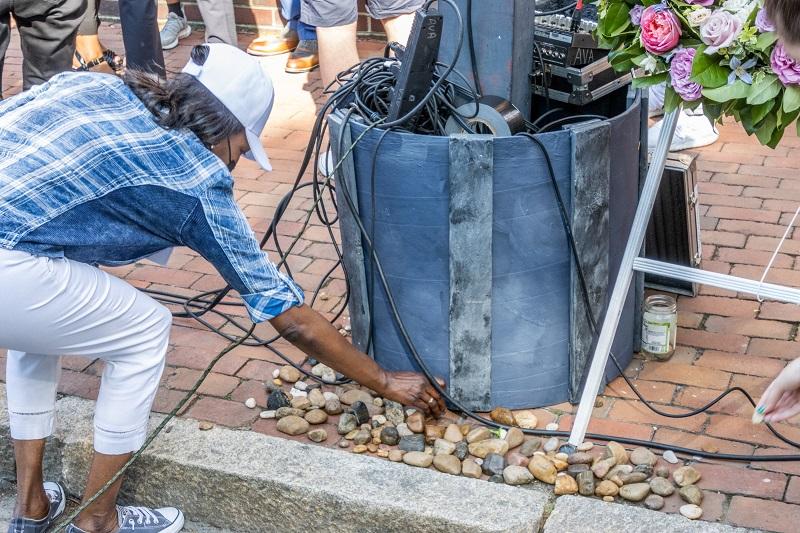 A participant places a stone at the site of the lynching