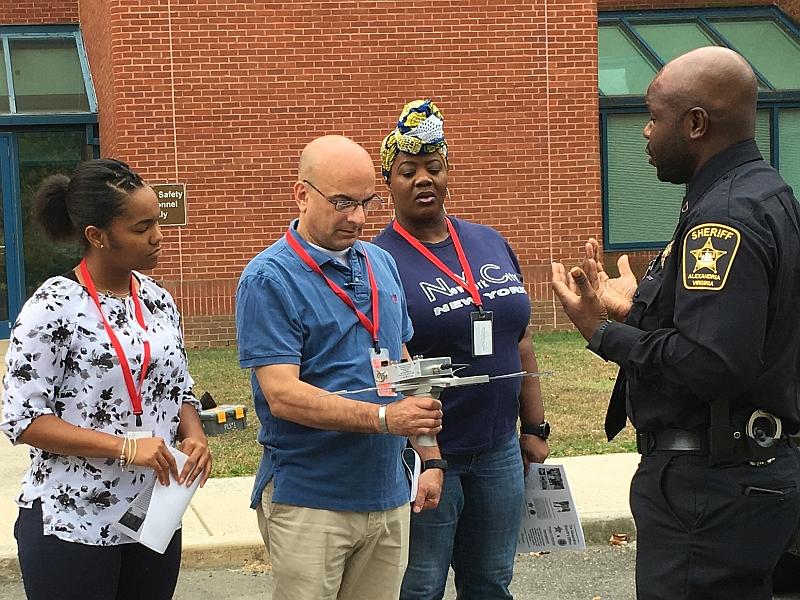 deputy discussing tracking technology with three civilians 