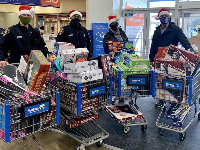 four people with holiday hats and shopping carts full of toys