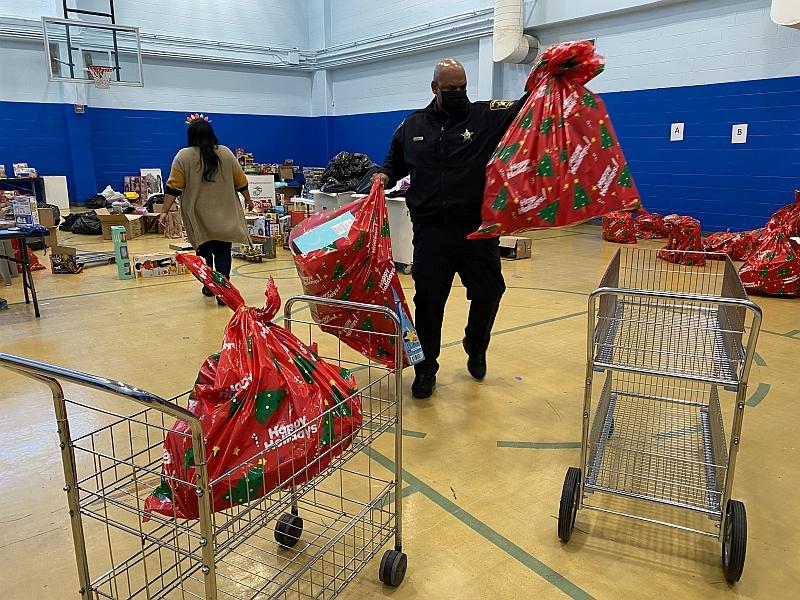 deputy packing large holiday gift bags