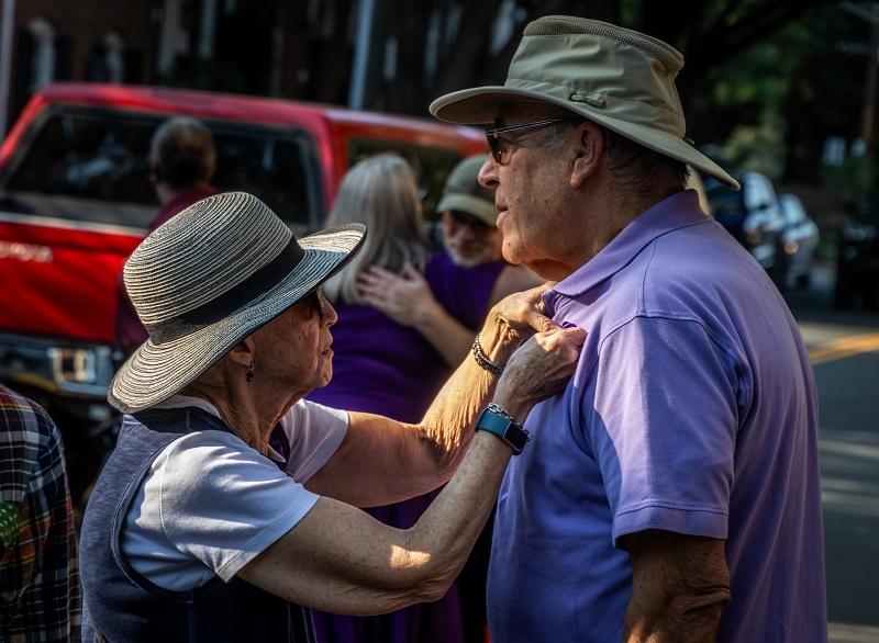 pinning on a purple ribbon