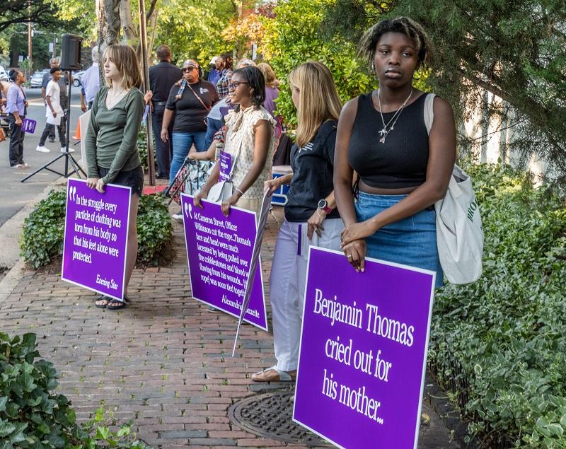 Students with signs, white quotes on purple background