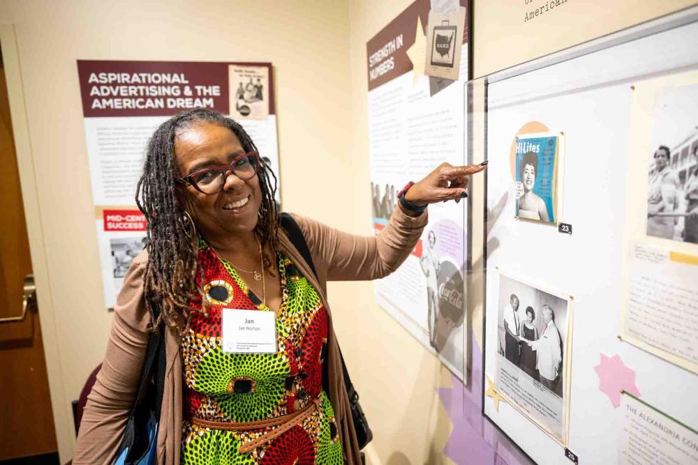 Woman pointing to image in exhibit