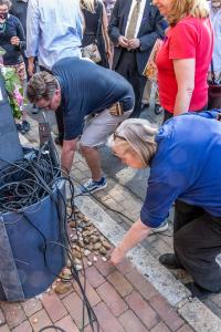 Two participants place stones at the site of the lynching