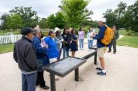 Group gathered around sign and guide