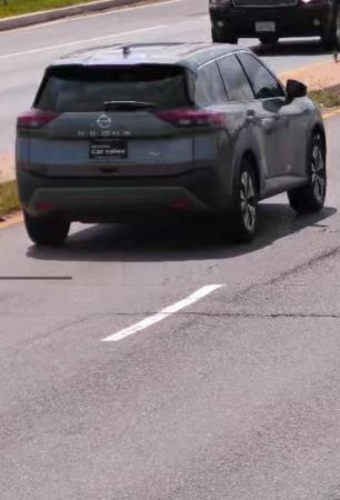 silver Nissan Rogue with “Enterprise Car Sales” placard in the rear license plate holder