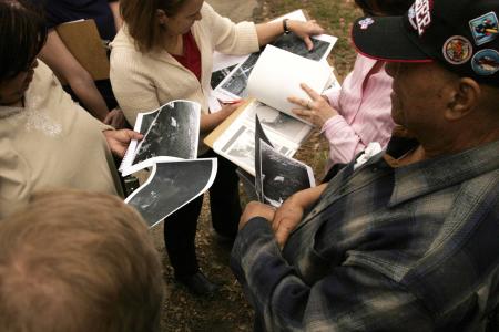 Community members hold photos during an oral history of The Fort.