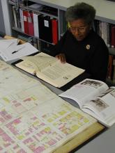 A researcher looks over maps and books.